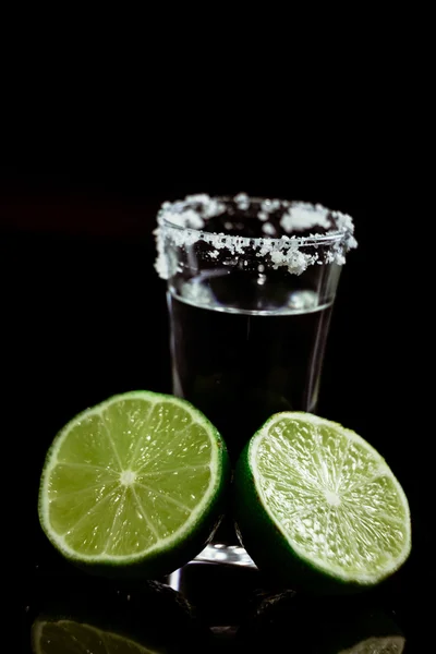 Tequila mit Limette auf schwarzem Hintergrund — Stockfoto