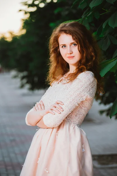 Bir bahçede poz pembe elbiseli güzel genç kadın — Stok fotoğraf
