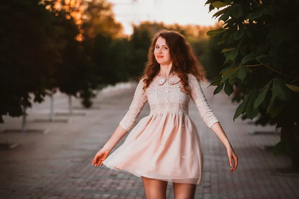 Hermosa joven con un vestido rosa posando en un jardín —  Fotos de Stock