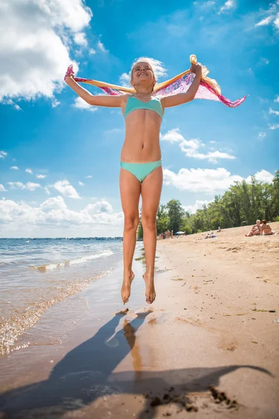 Little girl jumping high in water of a sea — Stock Photo, Image