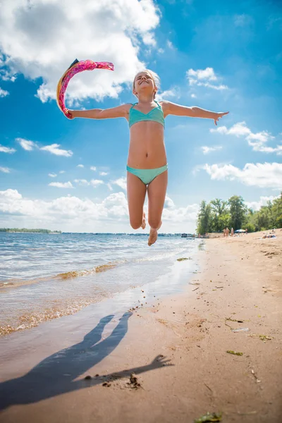 Little girl jumping high in water of a sea — Stock Photo, Image