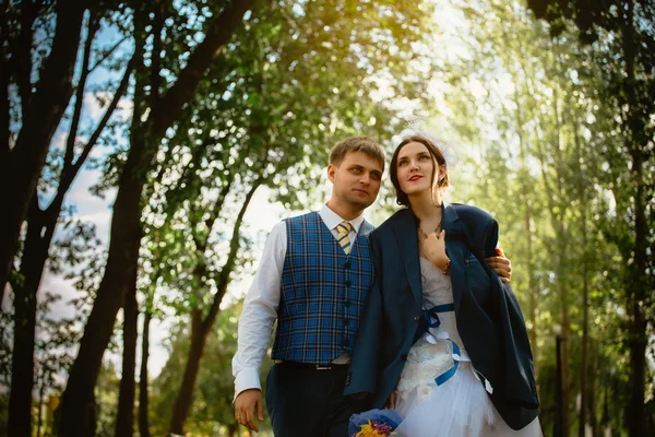 Noiva feliz, noivo em pé no parque verde, beijando, sorrindo, rindo. amantes no dia do casamento . — Fotografia de Stock