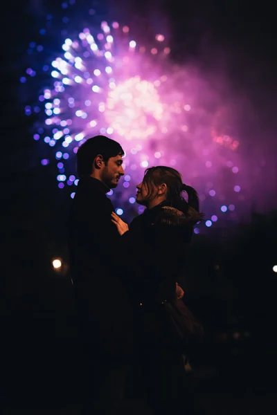 Una silueta de una pareja besándose frente a un enorme espectáculo de fuegos artificiales . —  Fotos de Stock