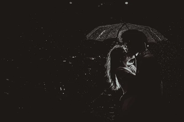 Dramatic photo of a bride and groom in the night rain. — 图库照片