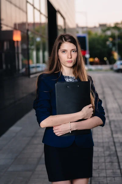 Successful businessman, standing against the backdrop of buildings holding  folder with sales charts. City business woman working. — Stockfoto