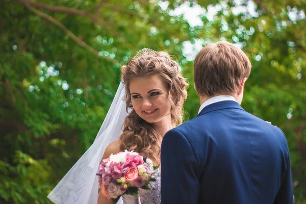 Beautiful young couple posing in the park on a background of nature — Stock Photo, Image