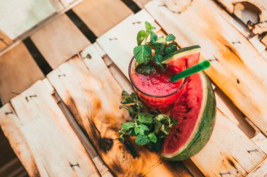 watermelon smoothie and fresh on a light wood background. selective focus to mint