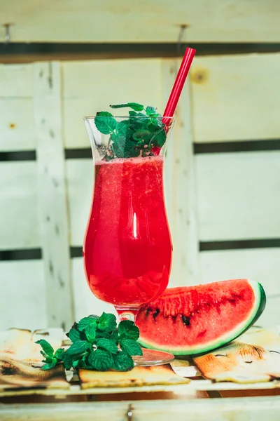 Wassermelonen-Smoothie und frisch auf hellem Holzgrund mit rotem Stroh. Selektiver Fokus auf Minze — Stockfoto