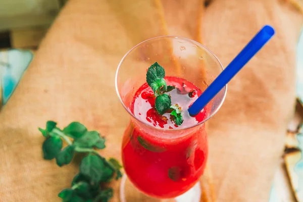 Wassermelonen-Smoothie und frisch auf Leinentuch vor hellem Holzhintergrund mit blauem Stroh. Selektiver Fokus auf Minze — Stockfoto