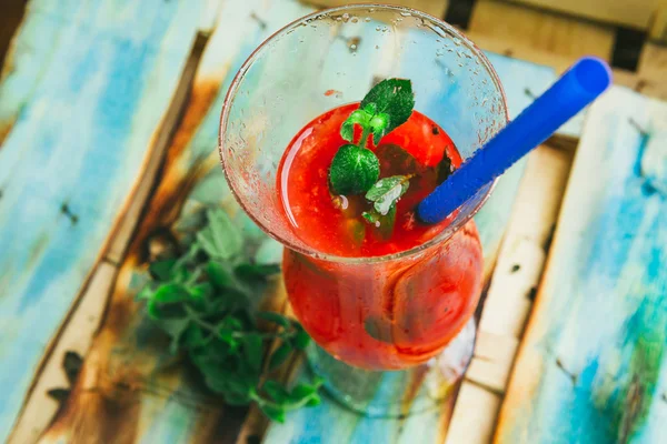 Wassermelonen-Smoothie auf hellem Skyey-Holz-Hintergrund mit blauem Stroh. Selektiver Fokus auf Minze — Stockfoto