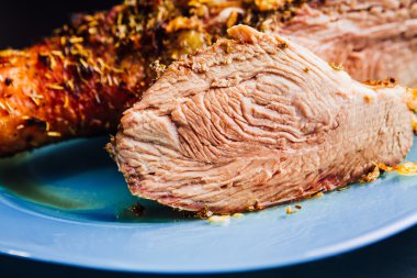 büyük taze pişmiş hindi budu ve siyah ahşap arka plan için mavi tabakta yalan baharatlar serpilir parça dilimlenmiş