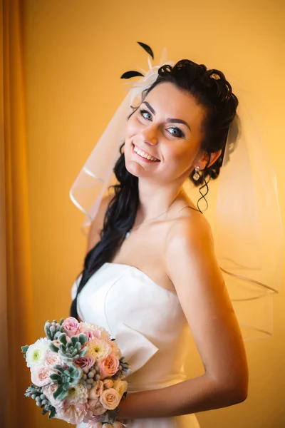Όμορφη νεαρός ευτυχισμένη νύφη που στέκεται κοντά στο παράθυρο — Φωτογραφία Αρχείου