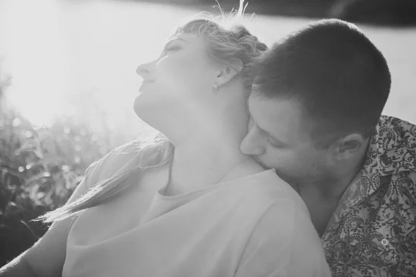 Romantique couple photo noir blanc assis et embrasser sur fond lac d'été — Photo