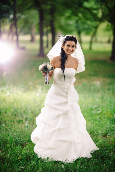 Bella giovane sposa stand su sfondo foresta — Foto Stock