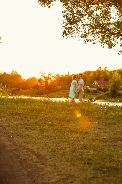 Romantisches Paar steht und küsst im Hintergrund Sommerwiese Sonnenuntergang — Stockfoto