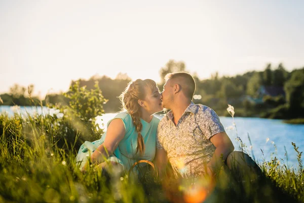 로맨틱 커플 앉아서 배경 여름 호수에 키스 — 스톡 사진