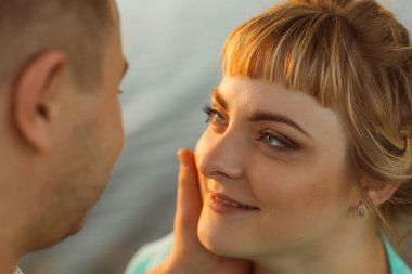 Romantik Çift ayakta ve arka plan yaz göl günbatımı üzerinde öpüşme