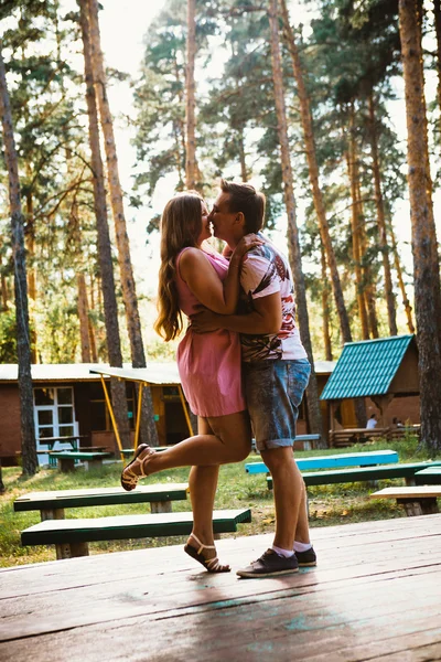 Романтическая молодая пара целуется на фоне летнего леса — стоковое фото