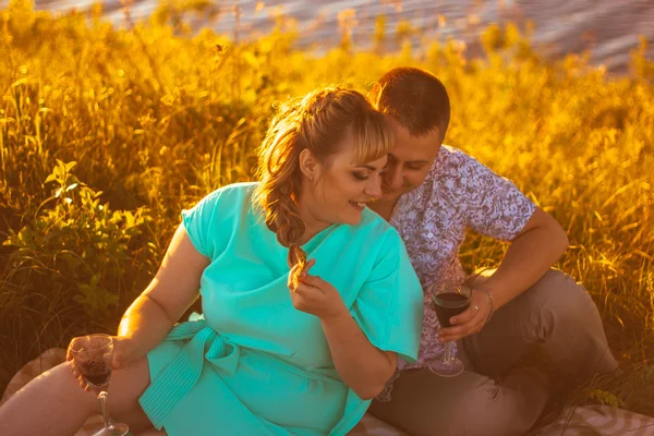 Romantic couple sit and kissing on background summer lake — Stock Photo, Image