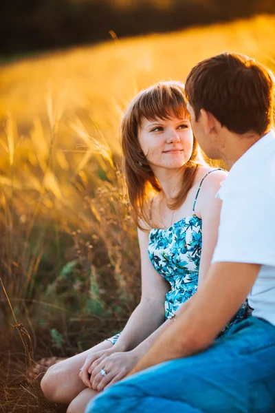 Casal romântico de pé e beijando no fundo verão prado por do sol — Fotografia de Stock