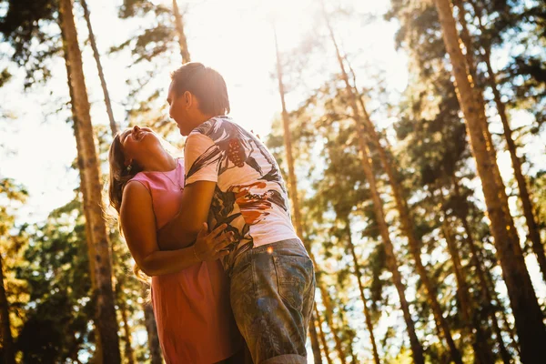 Романтическая молодая пара целуется на фоне летнего леса — стоковое фото