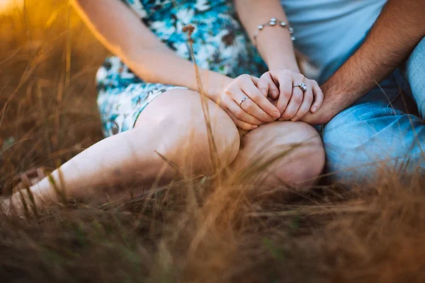 Couple romantique assis sur fond pré d'été coucher de soleil — Photo