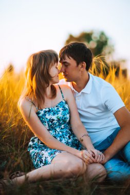 Romantik Çift ayakta ve arka plan yaz çayır sunset bulvarında öpüşme