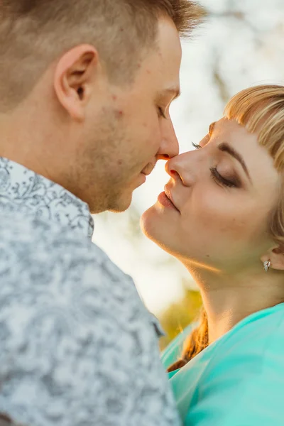 Romantiska par står och kysser på bakgrunden sommaren sjön sunset — Stockfoto