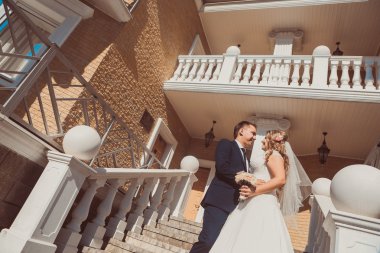 Gelin ve damat kucaklayan arka plan üzerinde duruyorlar şehir tam uzunlukta güzel mimari