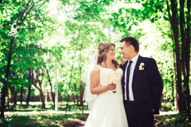 Mutlu çifte gelin ve damat kucaklayan bir ormanda stand