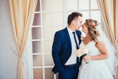 Gelin ve damat arka plan windows üzerinde bir otel odasında poz