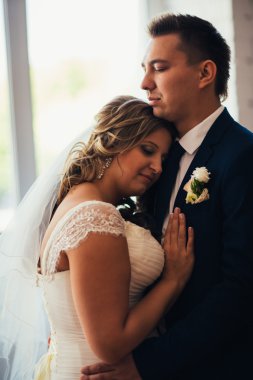 Gelin ve damat arka plan windows üzerinde bir otel odasında poz