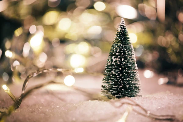Árbol de Navidad en miniatura en la nieve y decoraciones —  Fotos de Stock