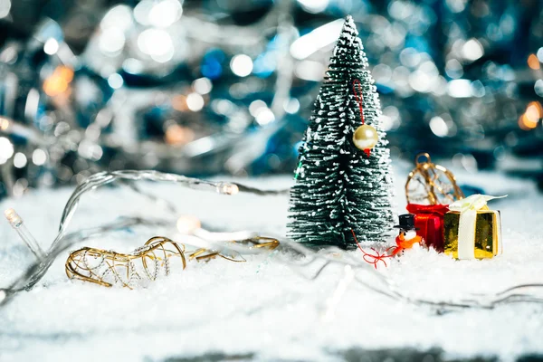 Árbol de Navidad miniatura, muñeco de nieve y regalos en la nieve —  Fotos de Stock