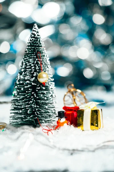 Miniatyr julgran, snögubbe och gåvor i snön — Stockfoto