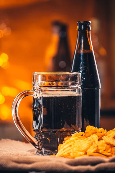 Стакан свежего пива, бутылочное пиво и чипсы на упаковке — стоковое фото