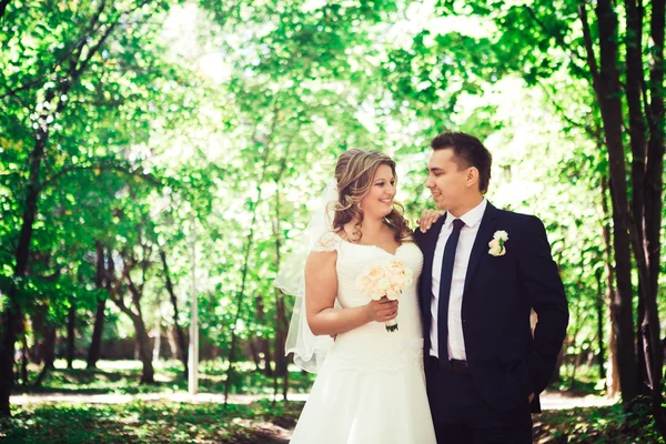 Heureux couple mariée et marié embrassant qu'ils se tiennent dans une forêt — Photo