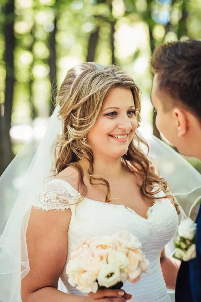 Happy couple bride and groom embracing they stand in a forest — Stock Photo, Image