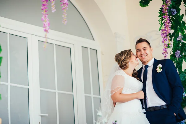 Novia y novio posando en una habitación de hotel en las ventanas de fondo — Foto de Stock