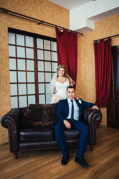 Bruid en bruidegom poseren in een hotelkamer — Stockfoto
