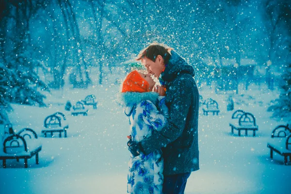 Beautiful young couple kiss  on snow park background — Stock Photo, Image