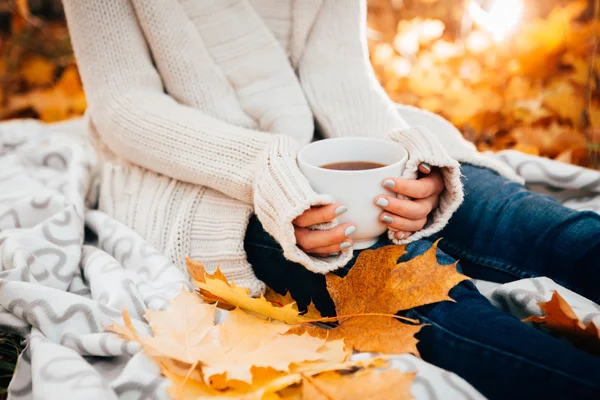 Young woman in a sweater and jeans relaxing drink tea on autumn background — Stock Photo, Image