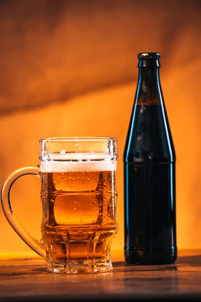 Fles en glas vers helder bier met Gerookte kaas vlecht op houten tafel — Stockfoto