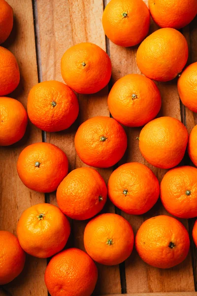 Many fresh tangerines on a wooden background — Stock Photo, Image