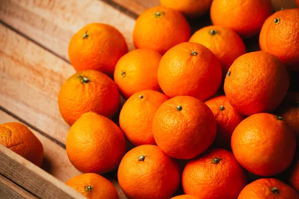 Muitas tangerinas frescas em um fundo de madeira — Fotografia de Stock