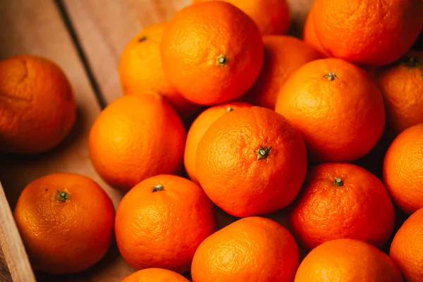 Viele frische Mandarinen auf einem hölzernen Hintergrund — Stockfoto
