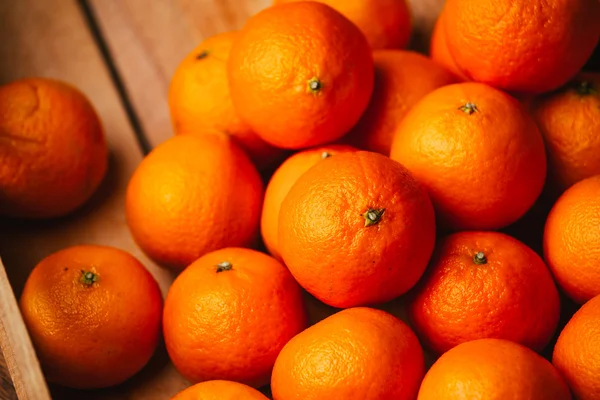 Muitas tangerinas frescas em um fundo de madeira — Fotografia de Stock