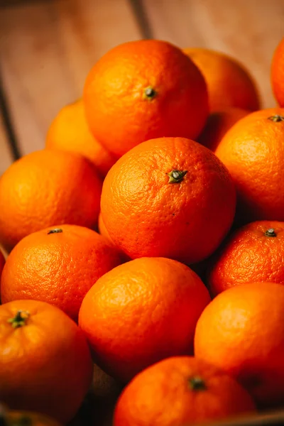 Muitas tangerinas frescas em um fundo de madeira — Fotografia de Stock