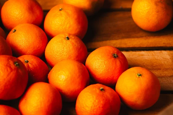 Muitas tangerinas frescas em um fundo de madeira — Fotografia de Stock