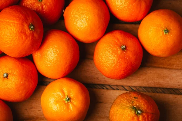 Viele frische Mandarinen auf einem hölzernen Hintergrund — Stockfoto